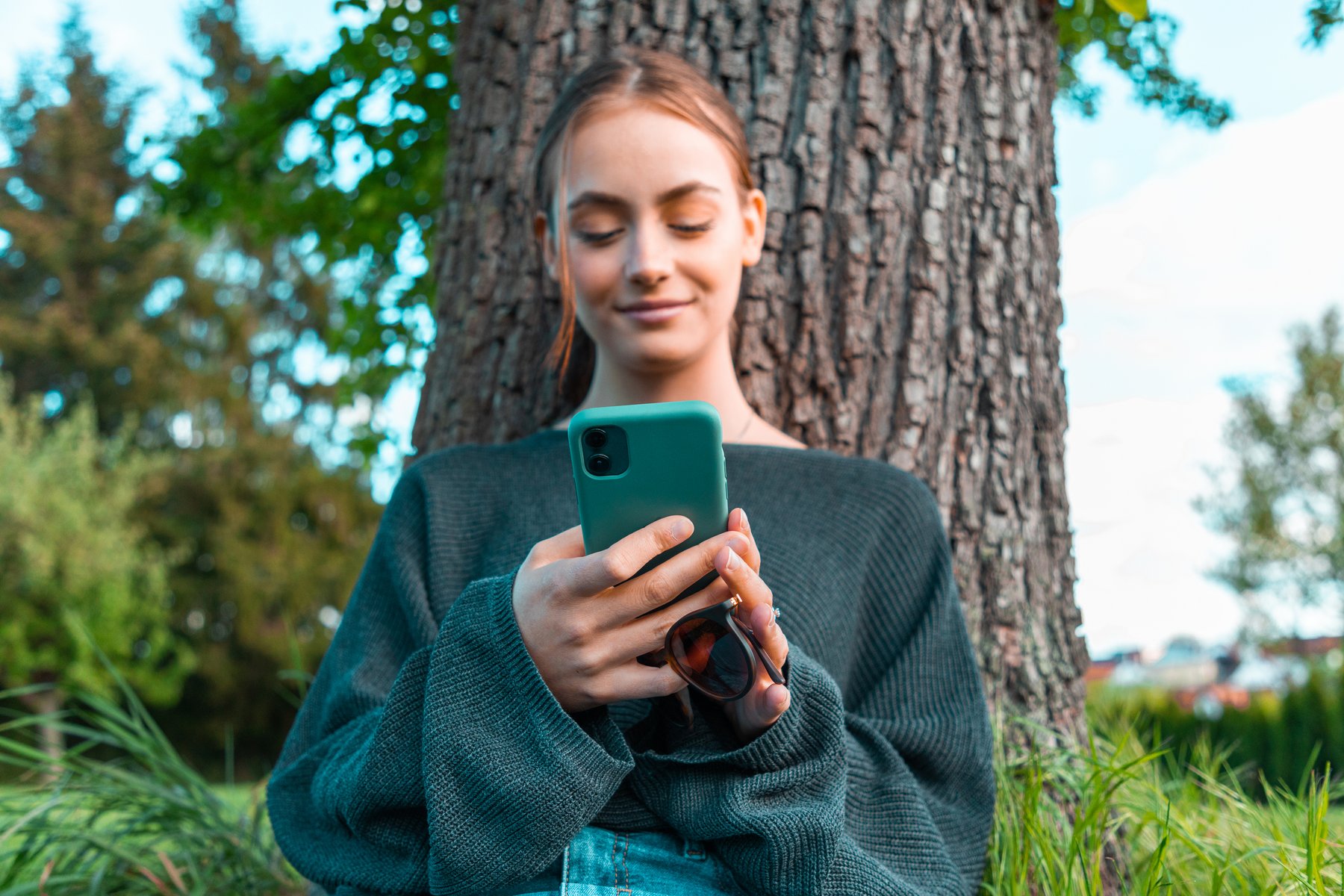 Frau schaut die die Brillant App an Frau_mit_Handy_am_Baum_.jpg