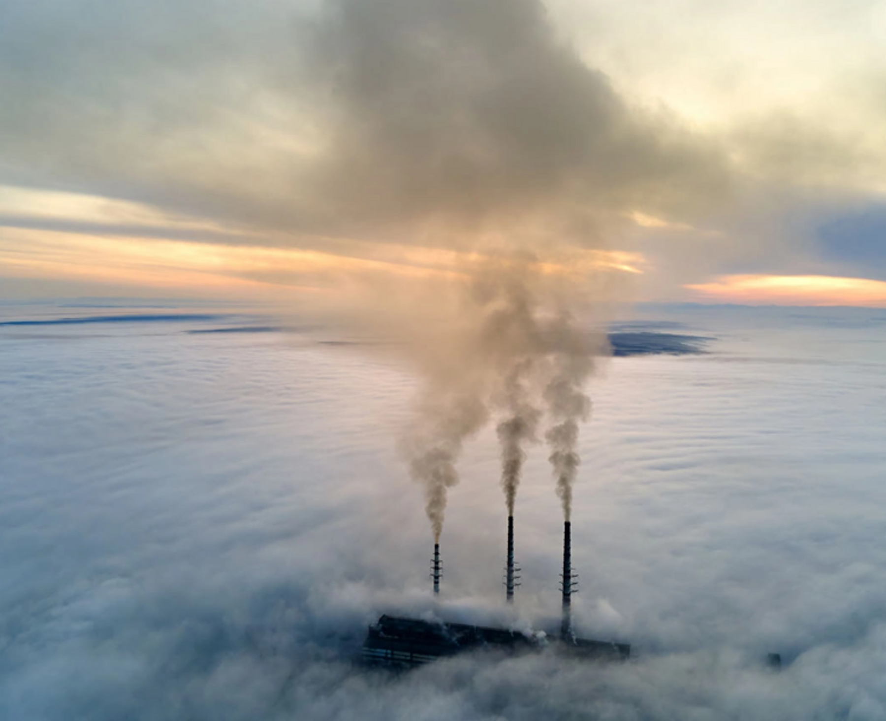 Aus mehreren Schornsteinen steigt rauch in die Luft Ausstoss_CO2-Emissionen-klimawirksamer_Ausgleich_Oekogas.png