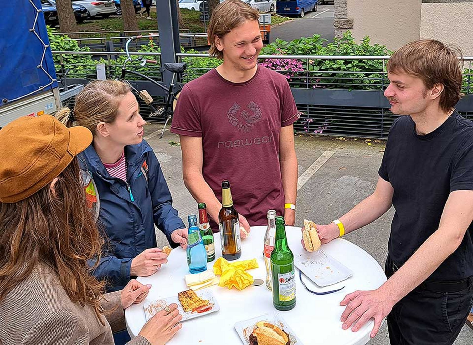 Mehrere Person stehen um einen Tisch herum Grillen_nach_Muellsammelaktion_Brillant_Energie.jpg